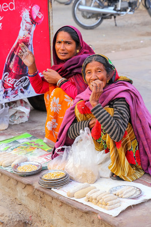 Local women selling fish food near Maota lake in Amber, Rajasthan, India. Amber Fort is the main tourist attraction in the Jaipur area.のeditorial素材