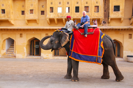 Decorated elephant with tourist walking in Jaleb Chowk (main courtyard) in Amber Fort, Rajasthan, India. Elephant rides are popular tourist attraction in Amber Fort.のeditorial素材