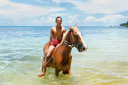 Young man riding horse on the beach on Taveuni Island, Fiji. Taveuni is the third largest island in Fiji.のeditorial素材