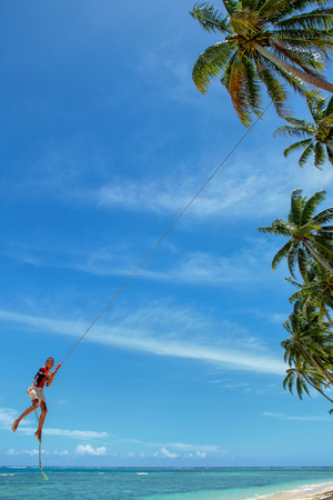 Local boy swinging on a rope swing in Lavena village, Taveuni Island, Fiji. Taveuni is the third largest island in Fiji.のeditorial素材