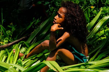 Local girl sitting in a grass in Lavena village, Taveuni Island, Fiji. Taveuni is the third largest island in Fiji.のeditorial素材