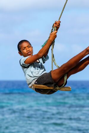 Local boy swinging on a rope swing in Lavena village on Taveuni Island, Fiji. Taveuni is the third largest island in Fiji.のeditorial素材