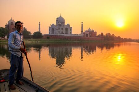 Local man steering boat on Yamuna river at sunset in front of Taj Mahal, Agra, India. It was build in 1632 by Emperor Shah Jahan as a memorial for his second wife Mumtaz Mahal.のeditorial素材