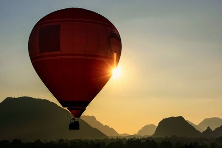 Hot air balloon flying in Vang Vieng, Vientiane Province, Laos. Vang Vieng is a popular destination for adventure tourism in a limestone karst landscape.の写真素材