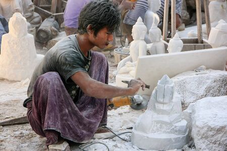 Local man working on a statue near Mahamuni Pagoda in Mandalay, Myanmar. Mandalay is the second largest city in Myanmar.のeditorial素材
