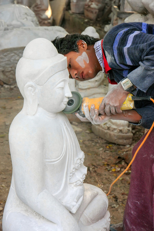Local man working on a statue near Mahamuni Pagoda in Mandalay, Myanmar. Mandalay is the second largest city in Myanmar.のeditorial素材