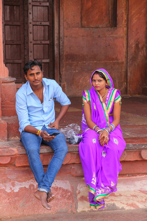 Young couple sitting in the courtyard of Jama Masjid in Fatehpur Sikri, Uttar Pradesh, India. The mosque was built in 1648 by Emperor Shah Jahan and dedicated to his daughter  Jahanara Begumのeditorial素材