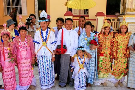 Local people in traditional costumes taking part in wedding ceremony at Mahamuni Pagoda, Mandalay, Myanmar. Mahamuni Pagoda is a Buddhist temple and major pilgrimage site in Myanmar.のeditorial素材