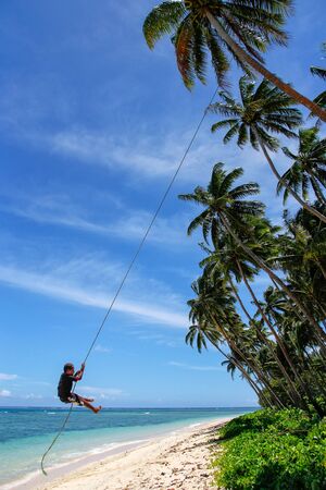 Local boy swinging on a rope swing in Lavena village, Taveuni Island, Fiji. Taveuni is the third largest island in Fiji.のeditorial素材