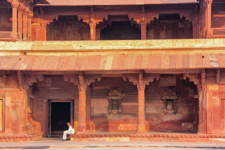 Man sitting in the inner courtyard of Jodh Bai Palace in Fatehpur Sikri, Uttar Pradesh, India. Fatehpur Sikri is one of the best preserved examples of Mughal architecture in India.のeditorial素材