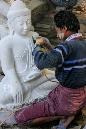 Local man working on a statue near Mahamuni Pagoda in Mandalay, Myanmar. Mandalay is the second largest city in Myanmar.のeditorial素材