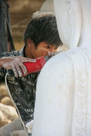 Local man working on a statue near Mahamuni Pagoda in Mandalay, Myanmar. Mandalay is the second largest city in Myanmar.のeditorial素材