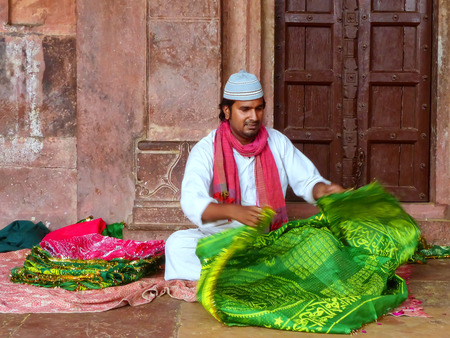 Local man folding cloth inside Jama Masjid in Fatehpur Sikri, Uttar Pradesh, India. The mosque was built in 1648 by Emperor Shah Jahan and dedicated to his daughter  Jahanara Begumのeditorial素材