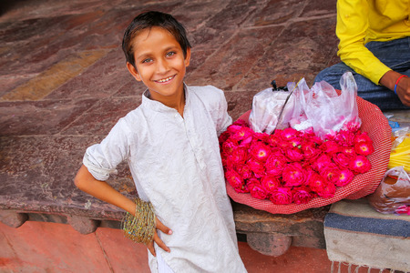 Local boy selling flowers in the courtyard of Jama Masjid in Fatehpur Sikri, Uttar Pradesh, India. The mosque was built in 1648 by Emperor Shah Jahan and dedicated to his daughter  Jahanara Begumのeditorial素材