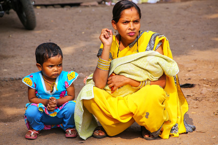 Local woman with a girl sitting at the street market in Fatehpur Sikri, Uttar Pradesh, India. The...