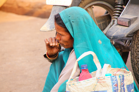 Local woman smoking at Kinari Bazaar in Agra, Uttar Pradesh, India. Agra is one of the most populous...