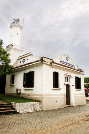 White colonial house  and a lighthouse in historic quarter of Colonia del Sacramento, Uruguay. It is one of the oldest towns in Uruguayのeditorial素材