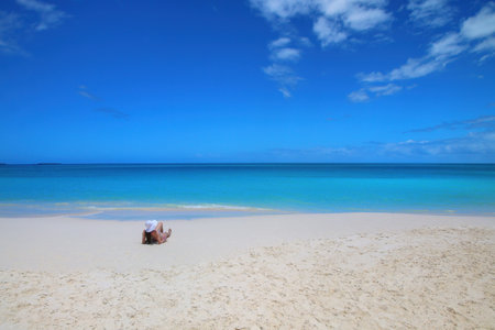 Woman relaxing on Fayaoue beach on the coast of Ouvea lagoon, Mouli and Ouvea Islands, New Caledonia. The lagoon was listed as Unesco World Heritage site in 2008.の写真素材
