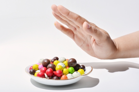 Female hand's gesture to rejecting color full chocholateの写真素材