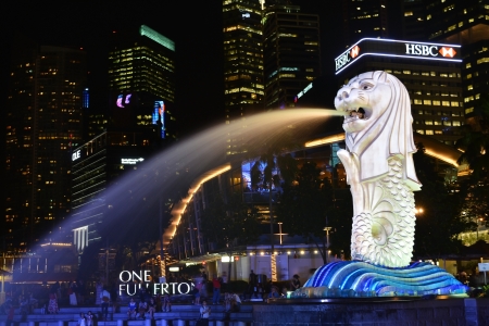 The Merlion fountain spouts water in front of the One Fullerton hotel at the night. Merlion is a mythical creature with the head of a lion and the body of a fish, and is a symbol of Singapore. のeditorial素材