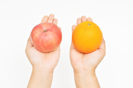 orange on the left hand and apple on the right handの写真素材
