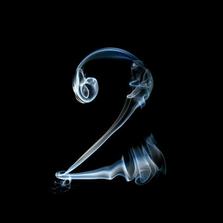 one letter from a smoky alphabet isolated on blackの写真素材