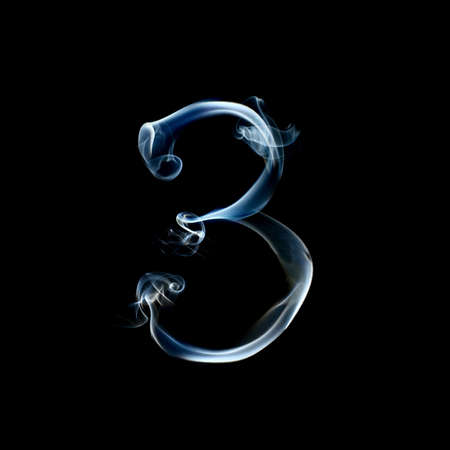 one letter from a smoky alphabet isolated on blackの写真素材