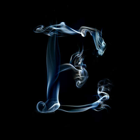 one letter from a smoky alphabet isolated on blackの写真素材