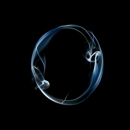 one letter from a smoky alphabet isolated on blackの写真素材