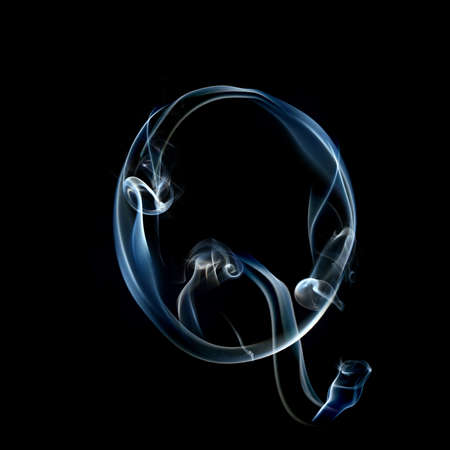 one letter from a smoky alphabet isolated on blackの写真素材