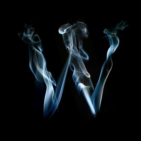 one letter from a smoky alphabet isolated on blackの写真素材