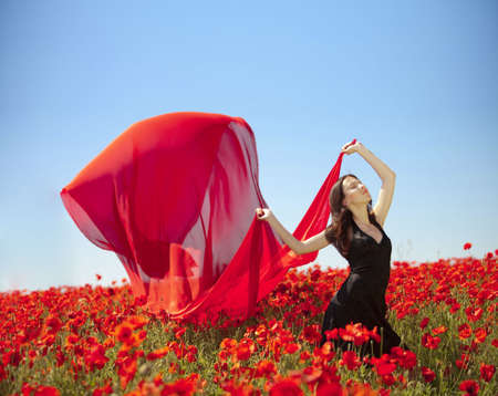 young pretty girl relaxing in the poppy fieldの写真素材