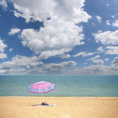 pink umbrella on the tropical beach backgroundの写真素材