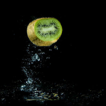 kiwi splashing out of water on black backgroundの写真素材