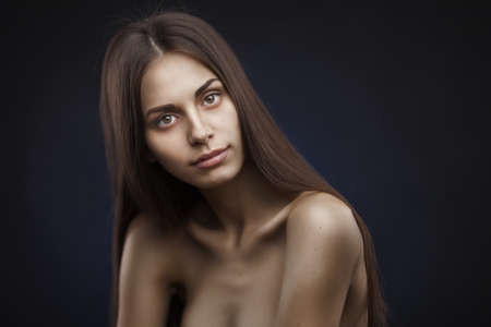 beautiful woman with long hair on dark backgroundの写真素材