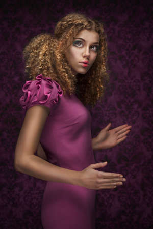 young beautiful doll girl with curly hairの写真素材