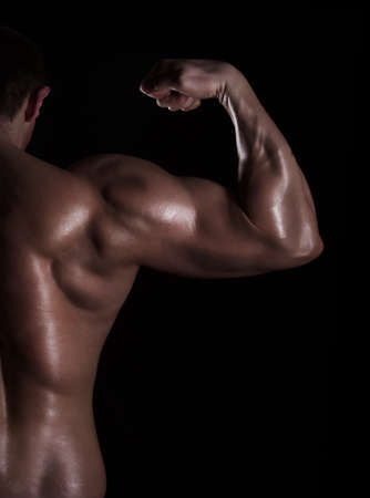 back view of a muscular man showing his bicepsの写真素材