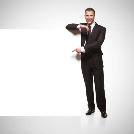 Portrait of business man showing blank signboardの写真素材