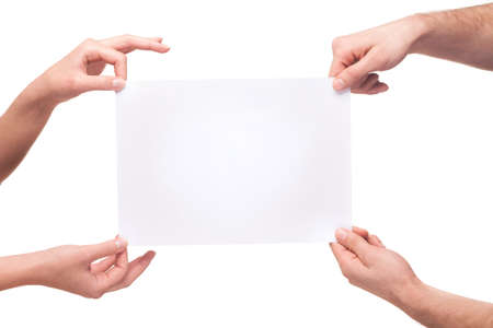 four hands holding a blank white boardの写真素材