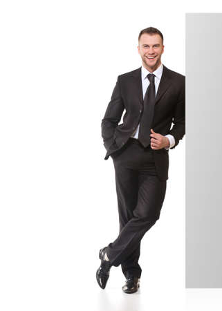 Portrait of happy smiling young business man with blank signboard isolated on white backgroundの写真素材