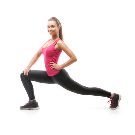 Smiling beautiful woman doing exercise isolated on white backgroundの写真素材