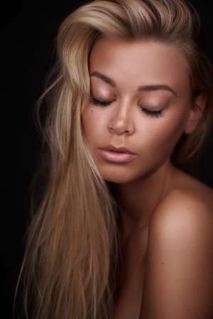Portrait of a stunning blonde beauty on dark backgroundの写真素材