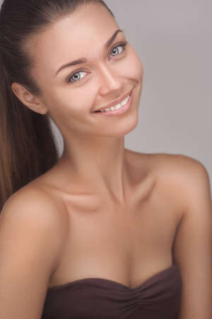 portrait of attractive caucasian smiling woman on grey studio backgroundの写真素材