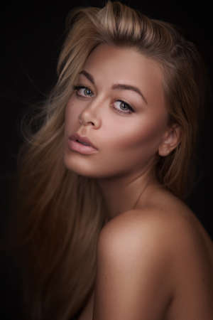 Portrait of a stunning blonde beauty on dark backgroundの写真素材