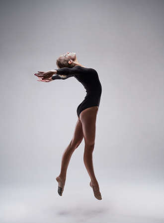 studio shoot of cute woman gymnast on grey studio backgroundの写真素材