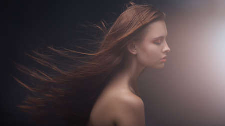 studio portrait of attractive young woman with long hair