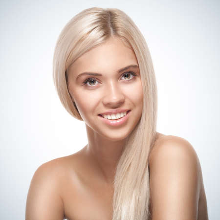 Young smiling woman with beautiful healthy face on blue gradient backgroundの写真素材