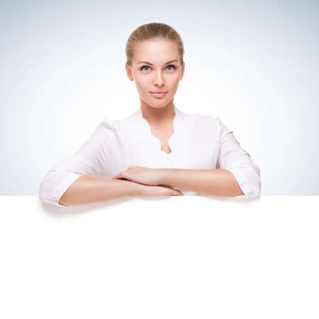 studio shot of beautiful young smiling woman over blue gradient white backgroundの写真素材