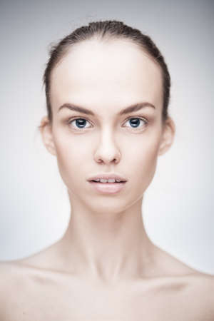 closeup portrait of a beautiful woman with clean face skin and nude makeup isolatedの写真素材