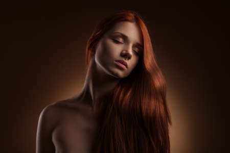 portrait of Beautiful Woman with Long Hair on dark studio backgroundの写真素材